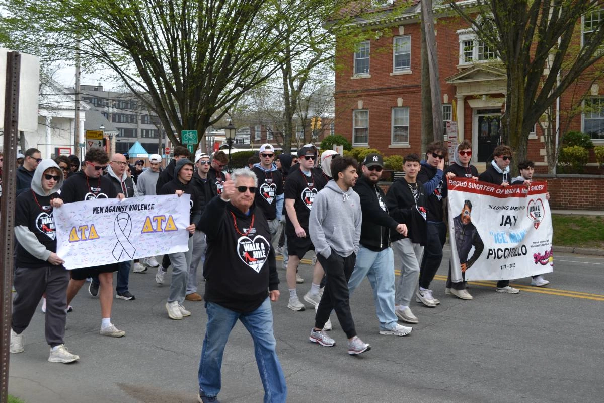 People marching and carrying banners at Walk a Mile in Her Shoes event