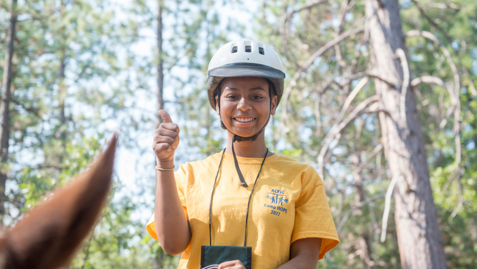 A young woman giving a thumbs-up